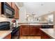 A kitchen features wood cabinets, black appliances, with a view of the living room at 464 N Jamestown Way, Aurora, CO 80018