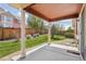 Relaxing covered patio with well-maintained yard and partial fence for added privacy at 464 N Jamestown Way, Aurora, CO 80018
