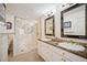 Bathroom featuring dual sinks, a large mirror, and a tiled shower with glass door at 210 N Garfield St, Denver, CO 80206