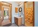 Cozy bathroom with wood vanity, updated lighting, and a decorative shower curtain at 2991 W 81St Ave # G, Westminster, CO 80031