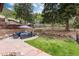 Landscaped backyard with a stone patio, mature trees, and serene mountain views at 200 Rose St, Georgetown, CO 80444