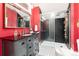 Bathroom featuring updated vanity, black tiled glass shower, and bright red walls at 200 Rose St, Georgetown, CO 80444