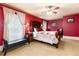 A bedroom features red walls, a carved-wood bed, and a window draped in lace curtains at 200 Rose St, Georgetown, CO 80444