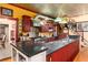 A chef's kitchen features a Viking range and hood, cherry cabinetry, granite counters, and stairs to the second floor at 200 Rose St, Georgetown, CO 80444
