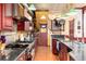 Galley style chef's kitchen features a Viking range and hood, cherry cabinetry, granite counters, and hardwood floors at 200 Rose St, Georgetown, CO 80444
