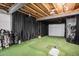 Golf simulator with artificial turf, projector screen, and golf equipment at 42363 Glen Abbey Dr, Elizabeth, CO 80107