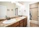 Well-lit bathroom boasts a double sink vanity with granite countertops, dark wood cabinets, and modern fixtures at 42363 Glen Abbey Dr, Elizabeth, CO 80107