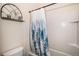Cozy bathroom featuring a tub and shower with a blue tree-themed shower curtain, complemented by decorative shelving at 42363 Glen Abbey Dr, Elizabeth, CO 80107