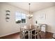 Cozy dining area with modern chandelier, rustic wood table and large window overlooking backyard at 42363 Glen Abbey Dr, Elizabeth, CO 80107