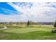 Scenic golf course with a winding path, calm water features, and mature trees under a partly cloudy sky at 42363 Glen Abbey Dr, Elizabeth, CO 80107