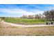 A lush green golf course with mature trees and a clear blue sky, offering a serene and picturesque view at 42363 Glen Abbey Dr, Elizabeth, CO 80107