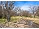 Scenic landscape with a winding creek, lush greenery, and mature trees at 42363 Glen Abbey Dr, Elizabeth, CO 80107