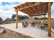 Outdoor patio with stone surround and wooden pergola, offers a cozy gathering space at 42363 Glen Abbey Dr, Elizabeth, CO 80107