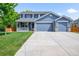 Charming two-story home featuring a covered front porch and a three car attached garage at 17395 E Dewberry Dr, Parker, CO 80134