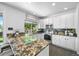 Modern kitchen with stone countertops, stainless appliances, and ample cabinet space at 17395 E Dewberry Dr, Parker, CO 80134