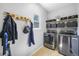 Well-organized laundry room with modern washer and dryer, storage shelves and coat rack at 17395 E Dewberry Dr, Parker, CO 80134