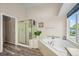 Relaxing main bathroom with soaking tub, shower, and natural light enhances the luxurious feel at 17395 E Dewberry Dr, Parker, CO 80134