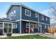 Rear exterior view of a home featuring a blue exterior, white trim, a patio, and a small yard at 2221 Illinois St, Golden, CO 80401