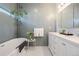 Bright bathroom with free-standing tub and white vanity, tiled with accentuating blue tiling at 2221 Illinois St, Golden, CO 80401
