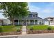 Charming two-story home with a covered front porch, landscaped lawn, and stone retaining wall at 2221 Illinois St, Golden, CO 80401
