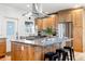 Modern kitchen featuring a granite island, stainless steel appliances, and beautiful natural wood cabinetry at 2221 Illinois St, Golden, CO 80401