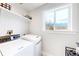 This laundry room has a large window, white machines and a shelf for storage at 2221 Illinois St, Golden, CO 80401