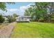 Expansive backyard featuring a well-maintained lawn, mature trees, and a charming deck at 6678 S Arapahoe Dr, Littleton, CO 80120