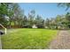 Green backyard featuring a shed, grass, a fence, and tall trees at 6678 S Arapahoe Dr, Littleton, CO 80120