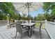 Outdoor deck with a large table, chairs, an umbrella, and a white railing at 6678 S Arapahoe Dr, Littleton, CO 80120