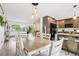Bright dining room with a wooden table, hanging lights, and kitchen view at 6678 S Arapahoe Dr, Littleton, CO 80120
