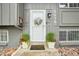 Charming entrance features a decorative wreath, potted plants, and a welcoming doormat at 6678 S Arapahoe Dr, Littleton, CO 80120