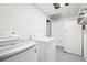 Functional laundry room with a washer, dryer, utility sink, and ample storage space at 6678 S Arapahoe Dr, Littleton, CO 80120
