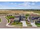 Elevated view of a modern home boasting stone accents, a three-car garage, and spacious surroundings at 8299 S Kellerman, Aurora, CO 80016