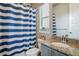 Compact bathroom featuring modern fixtures, a vanity with granite countertop and a blue-striped shower curtain at 8299 S Kellerman, Aurora, CO 80016