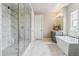 A sleek bathroom with marble features, a glass-enclosed shower, and a freestanding tub offers a spa-like experience at 8299 S Kellerman, Aurora, CO 80016