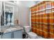 Cozy bathroom with granite counters, modern lighting, and orange striped shower curtain at 8299 S Kellerman, Aurora, CO 80016