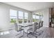 Well-lit dining area offering views of the green outdoor space through large windows and sliding glass doors at 8299 S Kellerman, Aurora, CO 80016