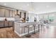 Open kitchen boasts a large island, granite counters, stainless appliances, and stylish pendant lighting at 8299 S Kellerman, Aurora, CO 80016