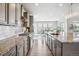 Well-lit kitchen with granite countertops, stainless steel appliances, ample cabinets, and a view of the dining area at 8299 S Kellerman, Aurora, CO 80016