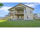 Exterior view of the backyard with a patio, green lawn, landscaping, and the home's architectural details at 1743 Homestead Dr, Fort Lupton, CO 80621
