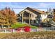 Beautiful backyard featuring a well-maintained lawn, a white fence, and mature trees at 1743 Homestead Dr, Fort Lupton, CO 80621