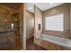 Bright bathroom with a walk-in shower and a soaking tub under a window providing natural light at 1743 Homestead Dr, Fort Lupton, CO 80621