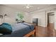 Bright bedroom featuring wood floors, a large window, a desk, and a comfortable bed at 1743 Homestead Dr, Fort Lupton, CO 80621