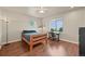Well-lit bedroom with wood floors, a ceiling fan, two windows, and a bed with blue covers at 1743 Homestead Dr, Fort Lupton, CO 80621