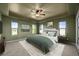 This bedroom features green walls and a ceiling fan, with natural light coming through the windows at 1743 Homestead Dr, Fort Lupton, CO 80621