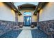 Inviting front entrance with stone accents, a decorative door, and manicured landscaping at 1743 Homestead Dr, Fort Lupton, CO 80621