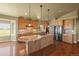 Spacious kitchen with stainless steel appliances, wood cabinets, and a central island at 1743 Homestead Dr, Fort Lupton, CO 80621