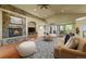 Comfortable living room with stone fireplace, hardwood floors, and views of the outdoor balcony at 1743 Homestead Dr, Fort Lupton, CO 80621