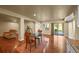 Spacious living room with wood floors, large windows, a dining table and access to outdoor spaces at 1743 Homestead Dr, Fort Lupton, CO 80621