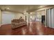 Open-concept living room with wood floors, sofa, dining area, kitchen, and access to other areas of the home at 1743 Homestead Dr, Fort Lupton, CO 80621